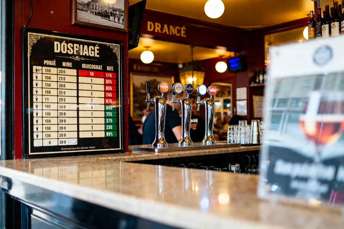 Tableau des doses d'alcool en bar cl devant des tireuses de bière dans un pub