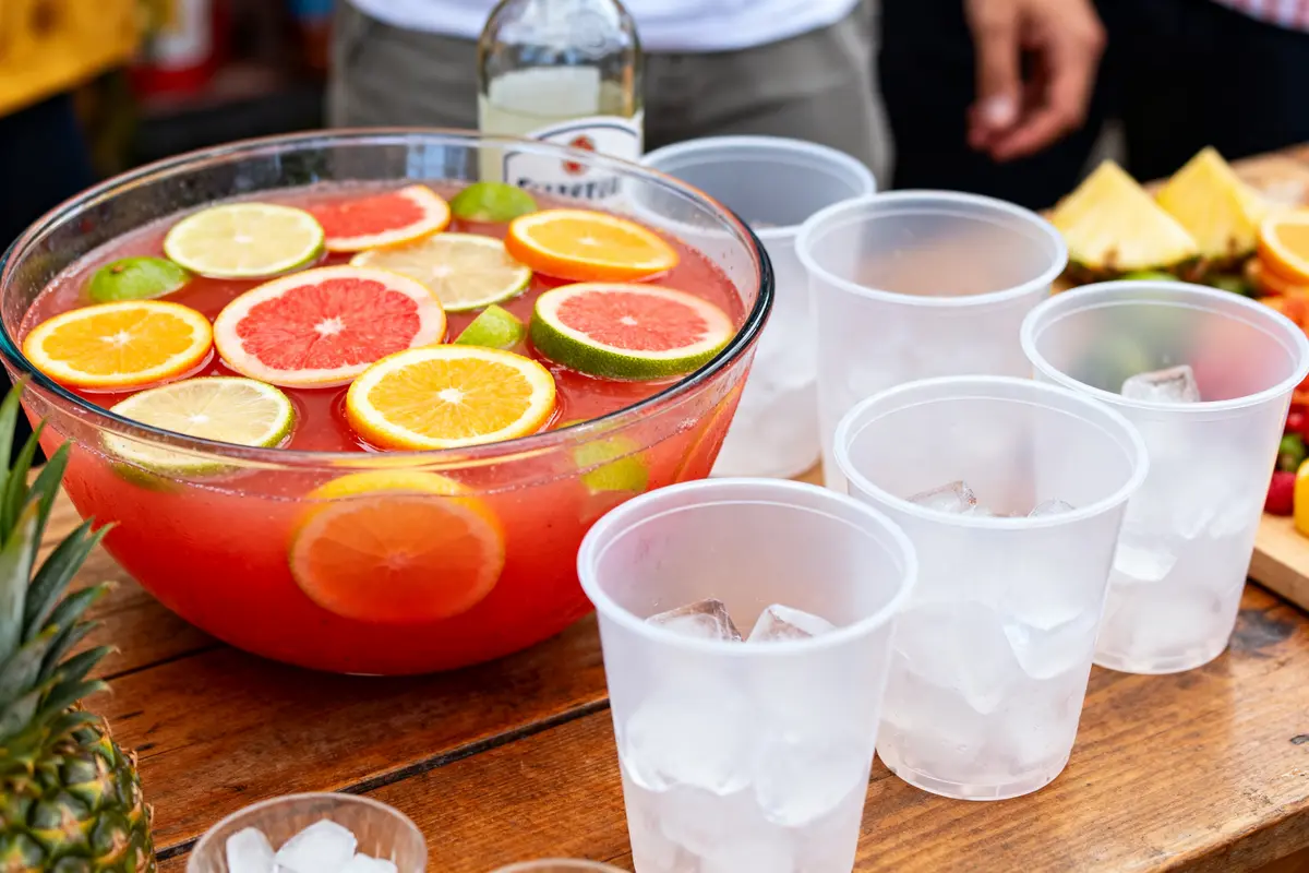 Grand bol de punch fruité avec des verres pour recette de punch pour 50 personnes