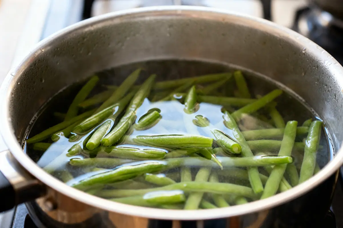 Casserole d'eau bouillante pour stériliser les haricots verts sur la cuisinière