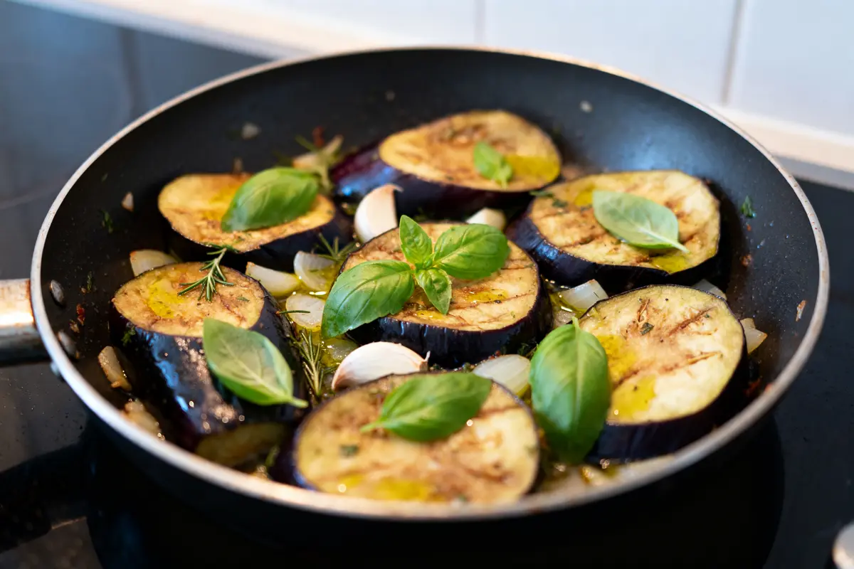 Tranches d'aubergines sautées avec herbes fraîches et ail dans une poêlée d'aubergines savoureuse
